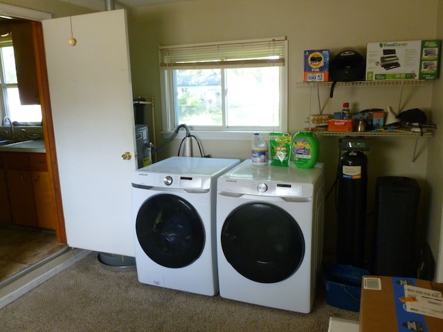 laundry room featuring washing machine and dryer, light colored carpet, and sink