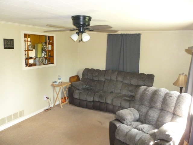 carpeted living room featuring ceiling fan and crown molding