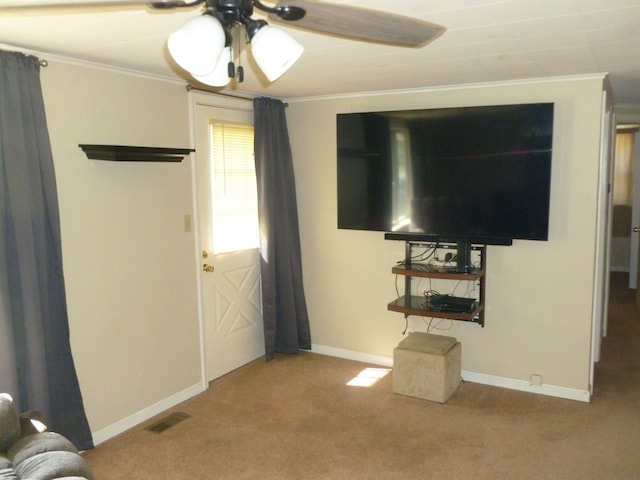 unfurnished living room featuring ceiling fan, carpet floors, and ornamental molding