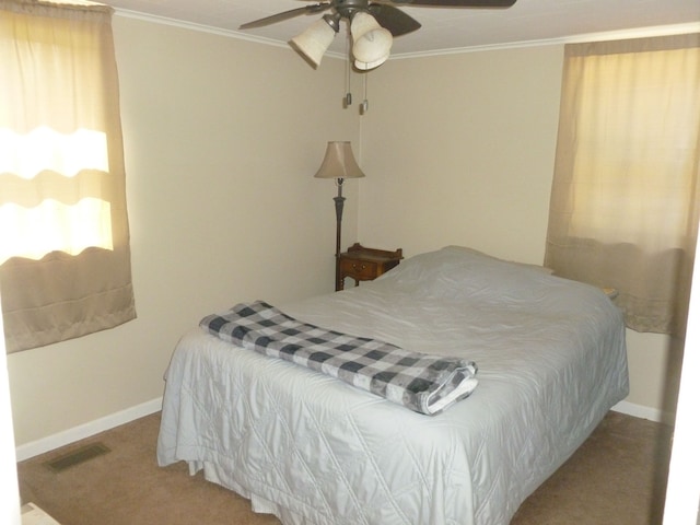 carpeted bedroom with ceiling fan and crown molding