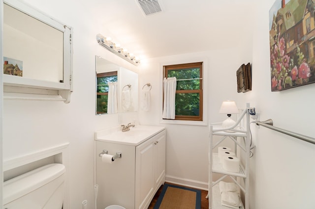 bathroom with hardwood / wood-style flooring, vanity, and toilet