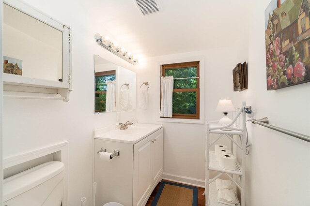 4281 Franklin Trl, Sterling, MI 48659 - bathroom with toilet, vanity, baseboards, and wood finished floors