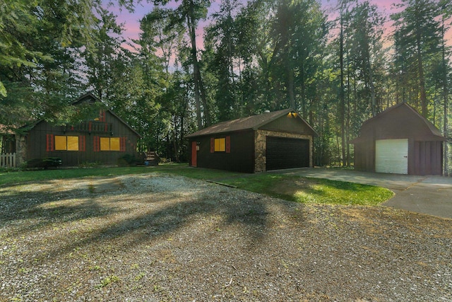 property exterior at dusk with a garage and an outdoor structure