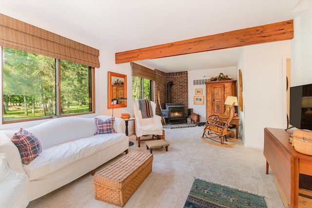 carpeted living room featuring beam ceiling and a wood stove