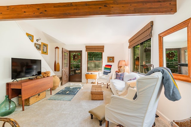 living room featuring beamed ceiling and carpet flooring