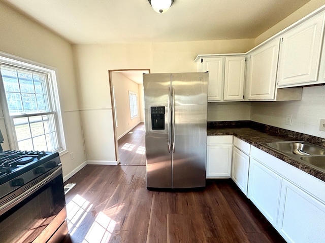 kitchen with sink, dark hardwood / wood-style floors, tasteful backsplash, white cabinetry, and stainless steel appliances