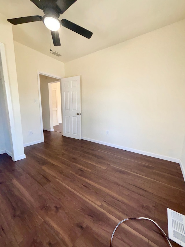 spare room with dark hardwood / wood-style floors and ceiling fan