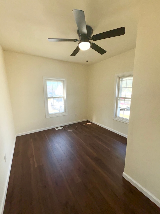 spare room featuring dark hardwood / wood-style floors, a healthy amount of sunlight, and ceiling fan