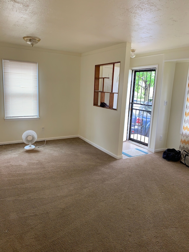 carpeted empty room with a textured ceiling