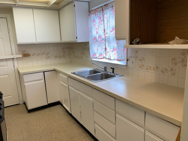 kitchen featuring white cabinets, backsplash, and sink