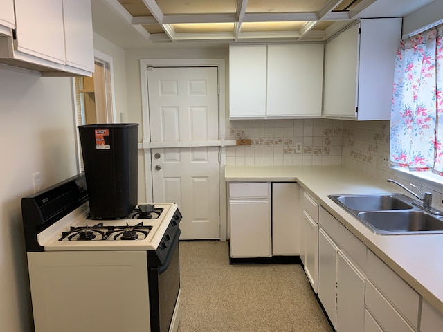 kitchen featuring white gas range, white cabinetry, sink, coffered ceiling, and decorative backsplash