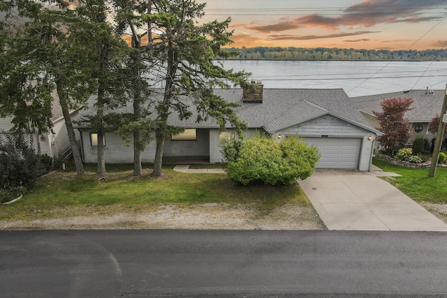 view of front of home with a water view and a garage