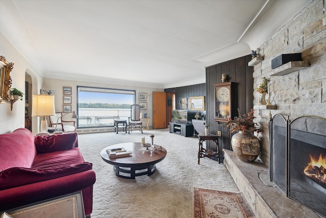 living room featuring carpet, a fireplace, and crown molding