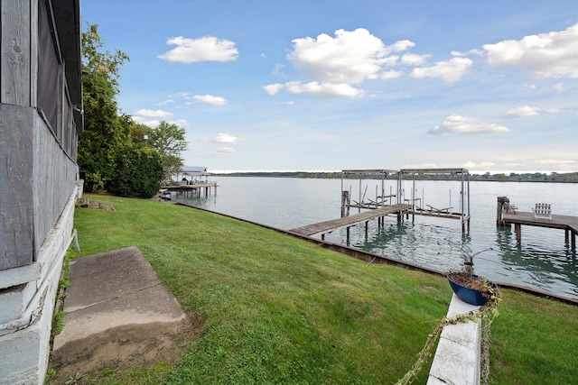 dock area with a yard and a water view