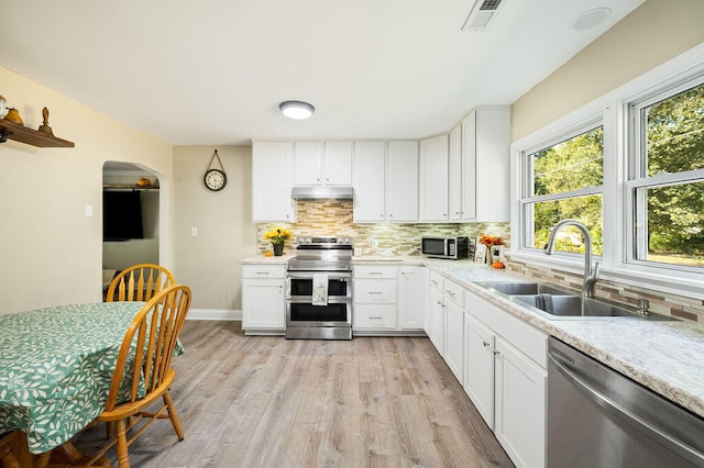 kitchen with stainless steel appliances, white cabinetry, and sink