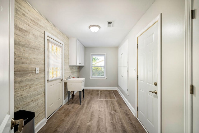 laundry room featuring hardwood / wood-style floors and cabinets