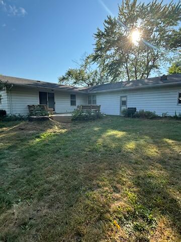 rear view of property featuring a yard