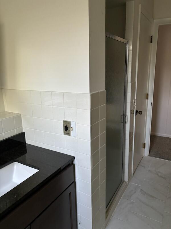 bathroom featuring vanity and a shower with shower door