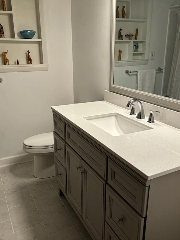 bathroom with tile patterned flooring, vanity, and toilet