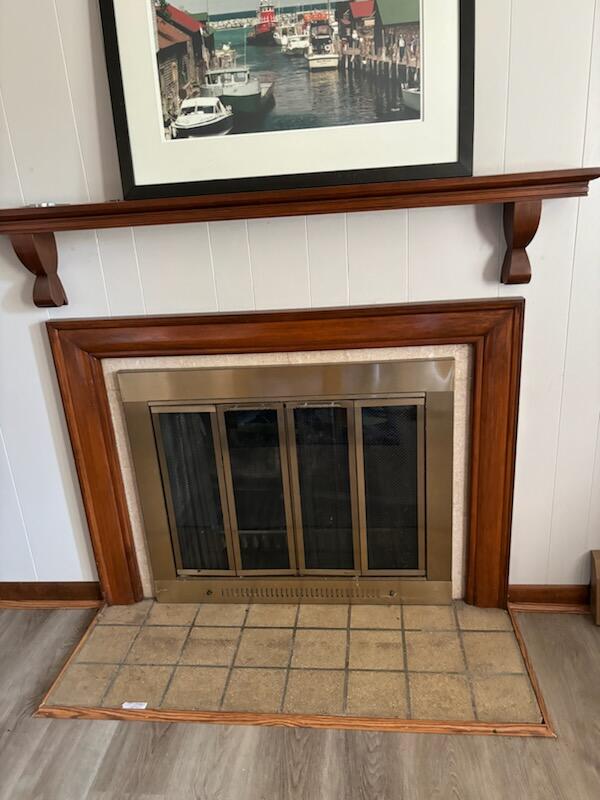 interior details with hardwood / wood-style flooring and a tiled fireplace