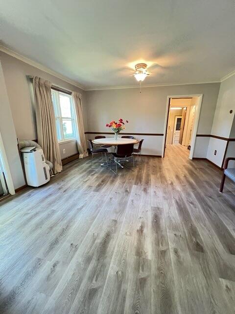 unfurnished dining area featuring hardwood / wood-style flooring and crown molding