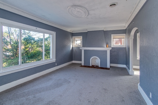 unfurnished living room featuring carpet flooring, a wealth of natural light, and crown molding