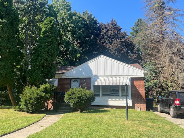 bungalow-style home with a front yard