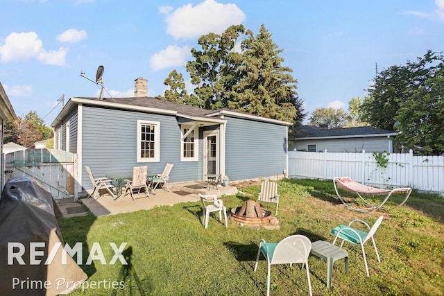 back of property featuring a patio, an outdoor fire pit, and a lawn