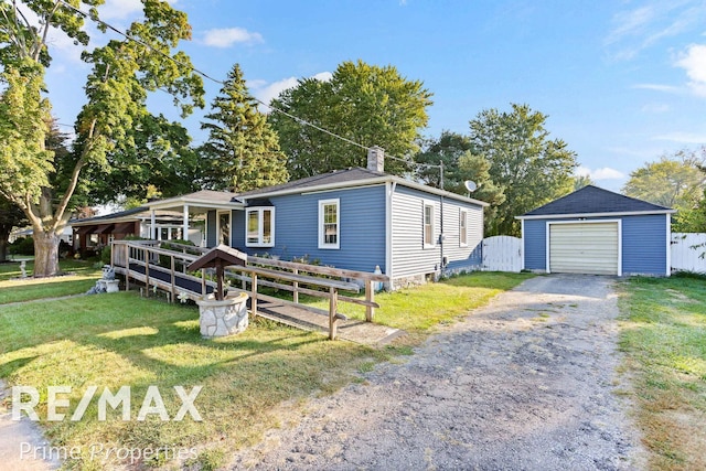 view of front of property with a garage, an outbuilding, and a front lawn