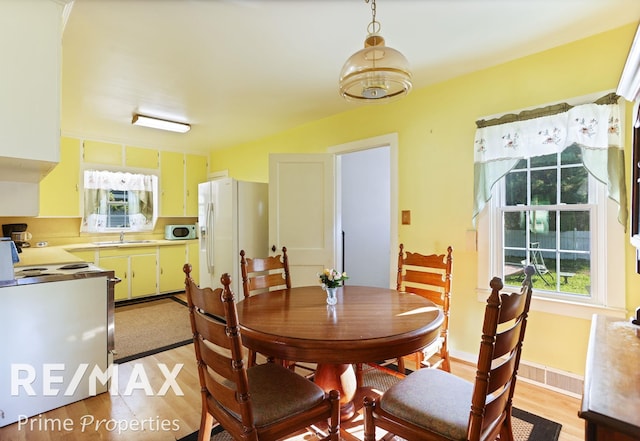 dining area featuring sink and light hardwood / wood-style floors