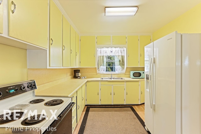 kitchen featuring light wood-type flooring, white appliances, and sink