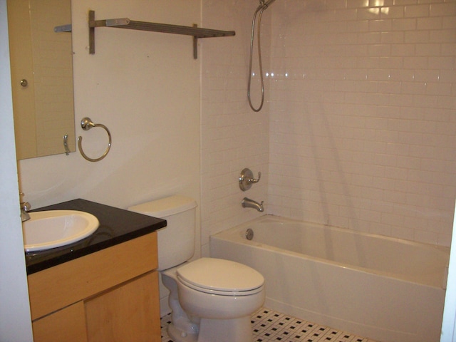 full bathroom featuring tile patterned floors, vanity, tiled shower / bath combo, and toilet