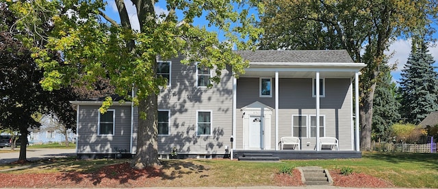 view of front of house featuring covered porch and a front yard