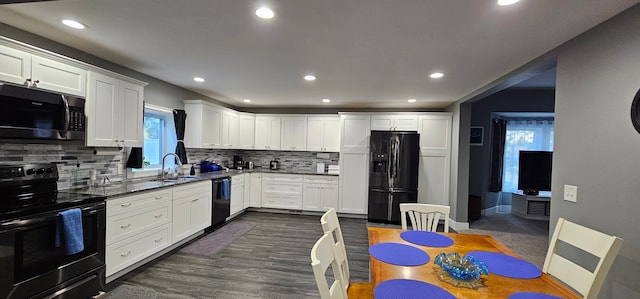 kitchen featuring black appliances, a healthy amount of sunlight, and white cabinetry