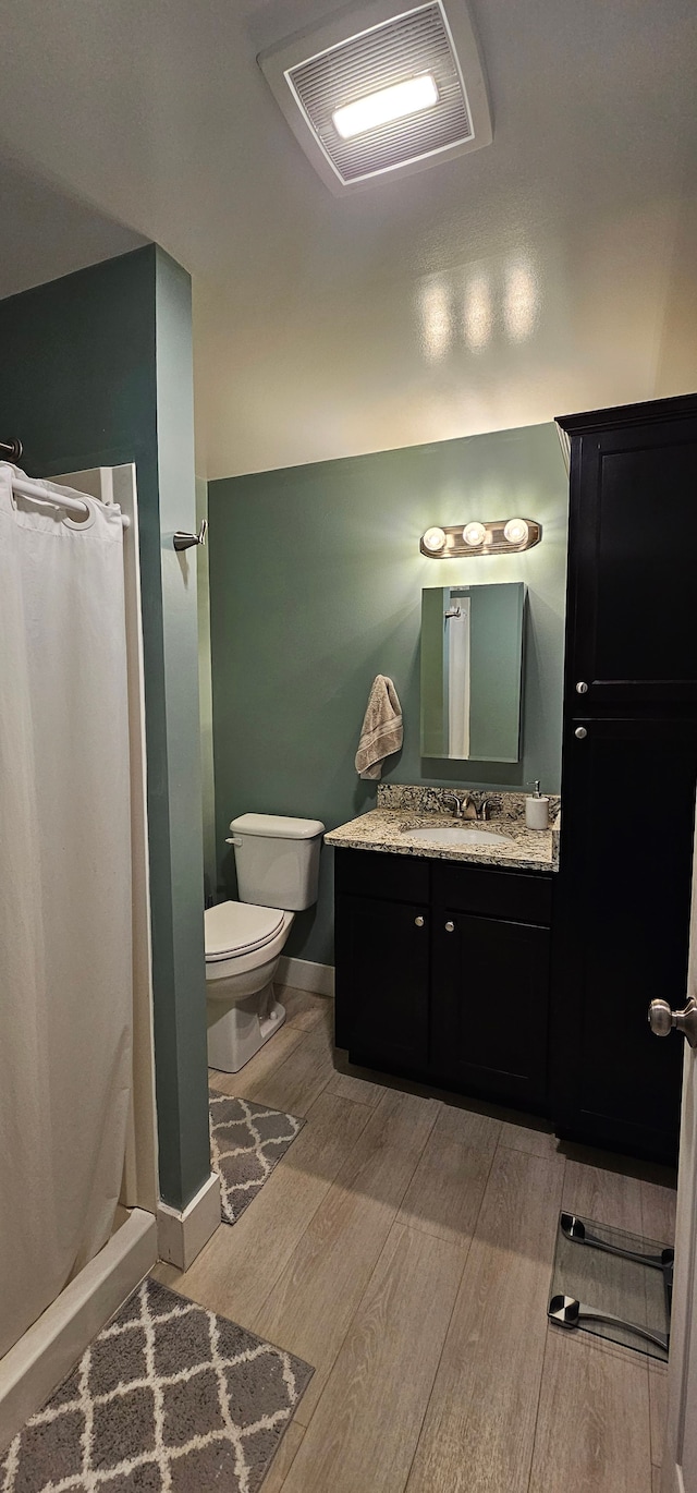 bathroom featuring vanity, toilet, a shower with shower curtain, and hardwood / wood-style flooring