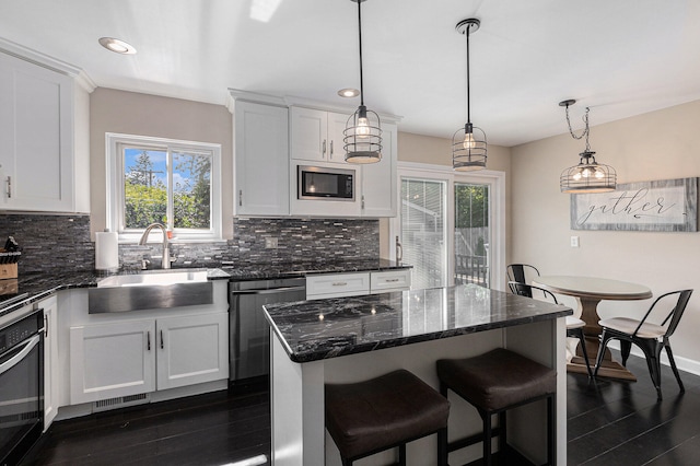 kitchen featuring white cabinetry, a center island, stainless steel appliances, and dark hardwood / wood-style floors