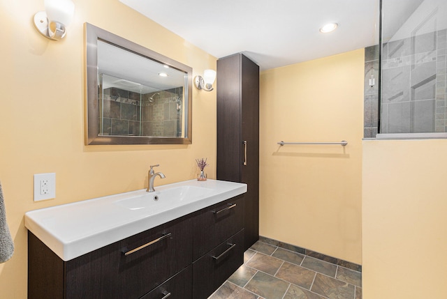 bathroom featuring a tile shower and vanity