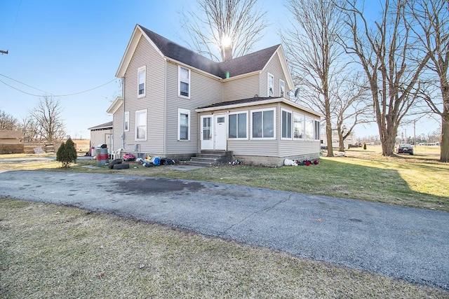 view of front facade with a front lawn and a sunroom