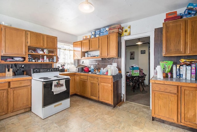 kitchen featuring backsplash, tile counters, sink, and white electric stove