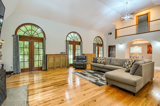 living room featuring french doors, light hardwood / wood-style flooring, and a wealth of natural light