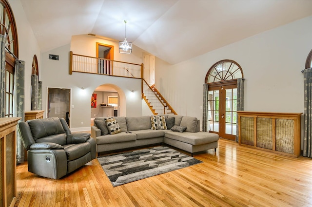 living room featuring french doors, high vaulted ceiling, and light hardwood / wood-style flooring