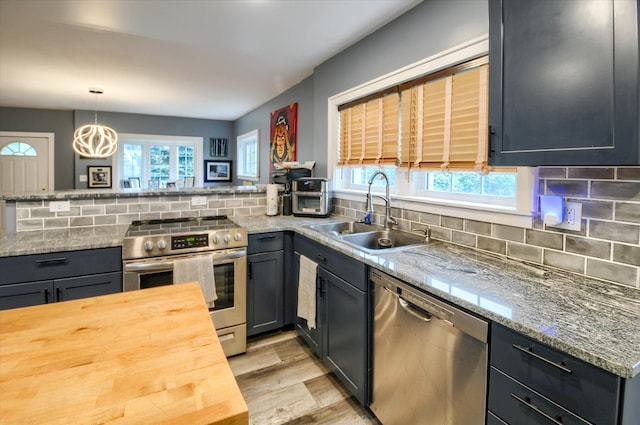 kitchen featuring tasteful backsplash, a wealth of natural light, sink, and appliances with stainless steel finishes