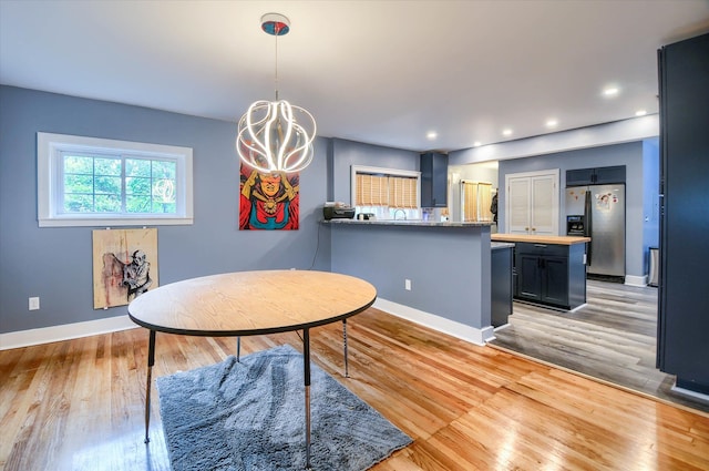 dining space featuring light hardwood / wood-style floors and a notable chandelier