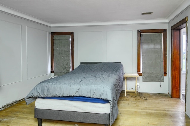 bedroom featuring light hardwood / wood-style flooring and crown molding