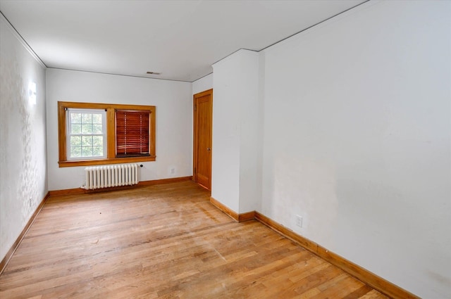 unfurnished room featuring light wood-type flooring and radiator