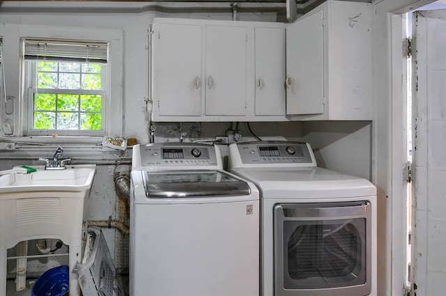 clothes washing area featuring cabinets and washing machine and clothes dryer