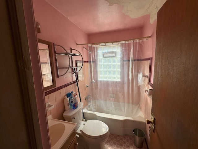 full bathroom with shower / bath combination with curtain, vanity, a textured ceiling, tile walls, and toilet