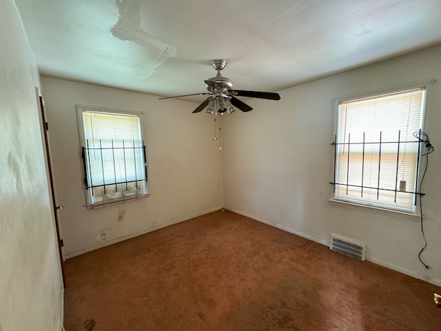 carpeted spare room with plenty of natural light and ceiling fan