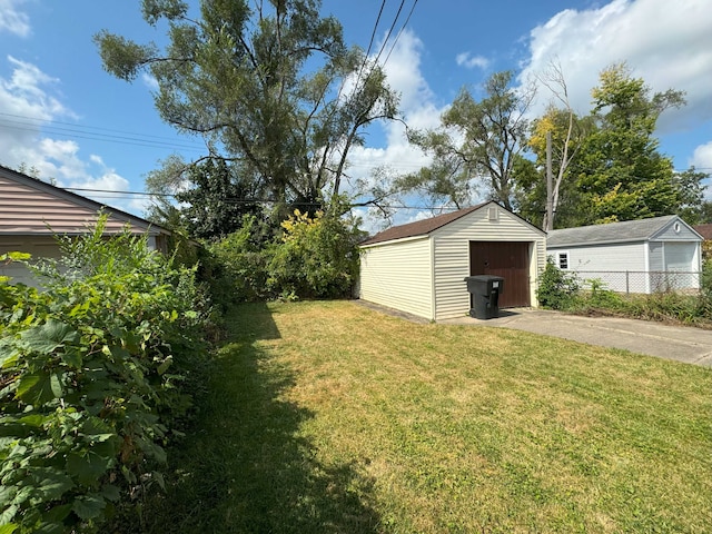 view of yard featuring a garage and an outbuilding