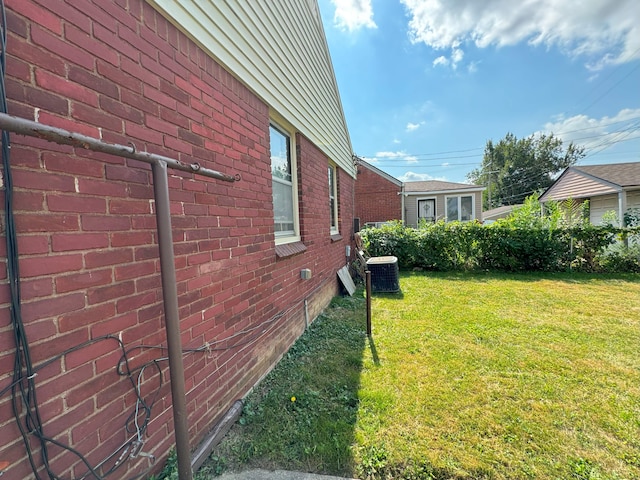 view of home's exterior featuring a yard and central AC